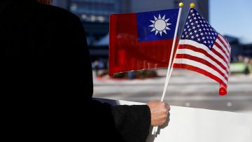 FILE PHOTO:  A demonstrator holds flags of Taiwan and the United States in support of Taiwanese President Tsai Ing-wen during an stop-over after her visit to Latin America in Burlingame