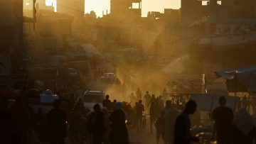 People walk at the remains of a market after an Israeli strike, in Khan Younis